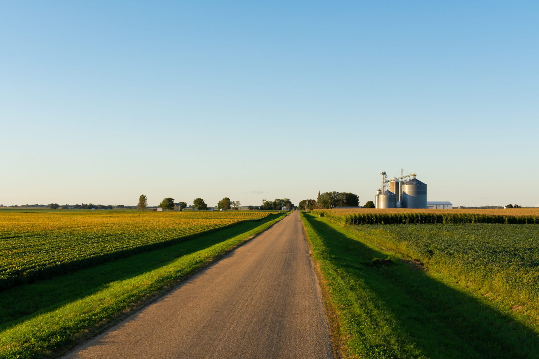 Open country road leading to small Midwest town.
